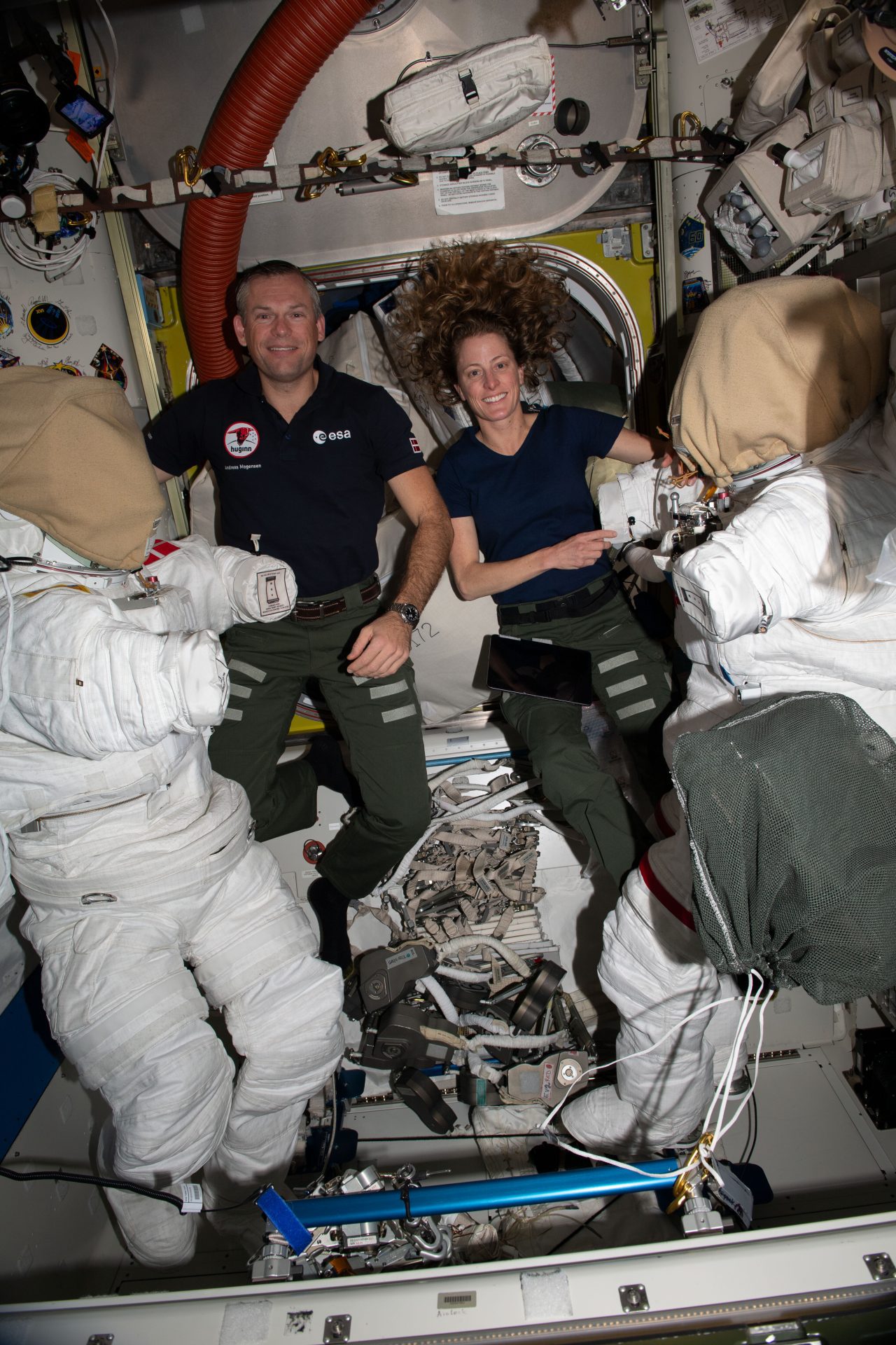 Astronauts Andreas Mogensen of ESA (European Space Agency) and Loral O'Hara of NASA service spacesuits inside the Quest airlock. The duo took turns cleaning cooling loops inside the suits ahead of a spacewalk planned for Oct. 12 to collect microbe samples from specific areas outside of the International Space Station. Scientists want to analyze the types of microbes that may be able to survive the harsh environment of outer space.