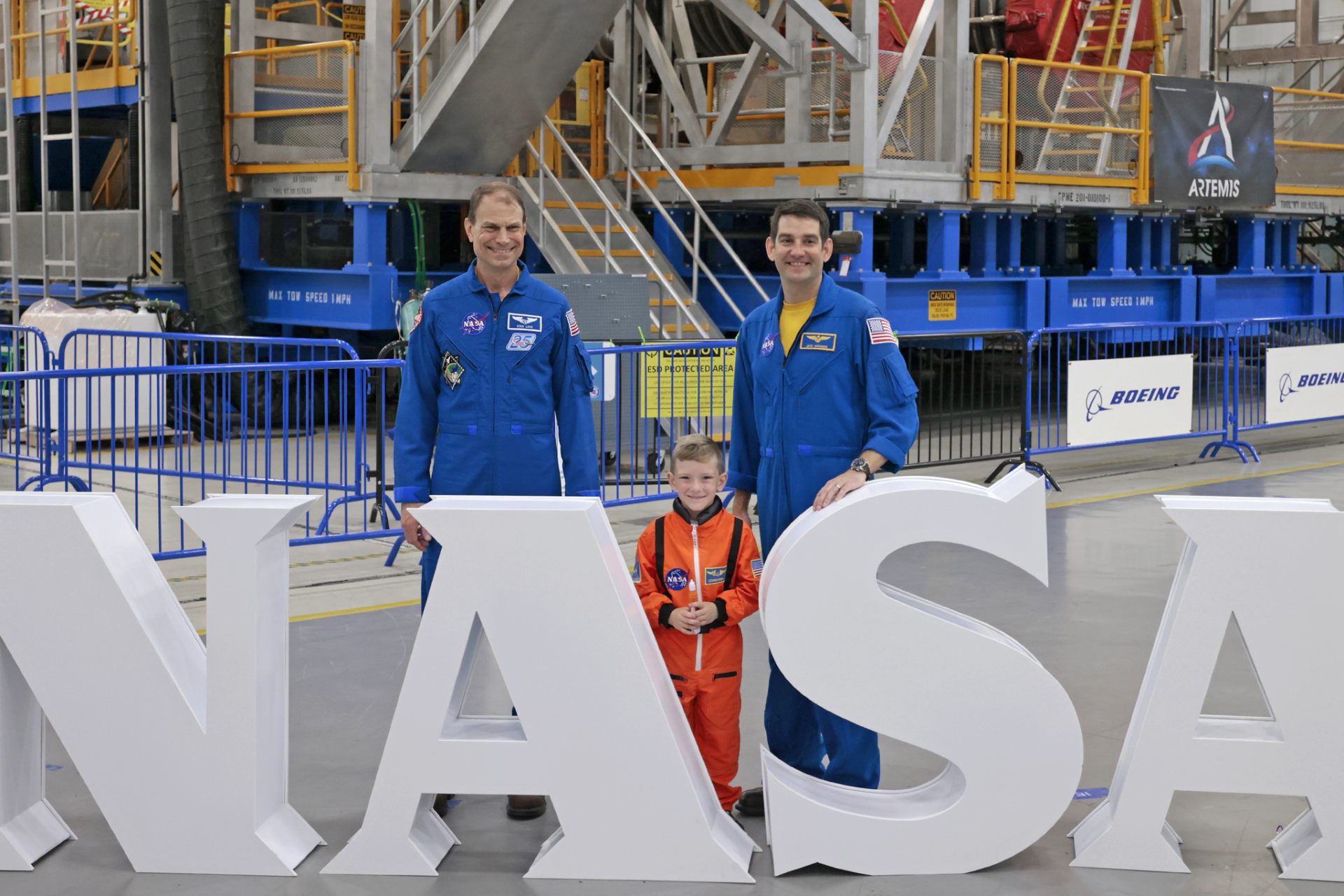 NASA astronaut Stan Love, left, and astronaut candidate Jack Hathaway pose for pictures with a young attendee at Michoud Family Day.