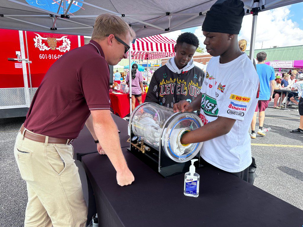 A NASA Stennis representative engages with the Artemis Generation at the Picayune Street Fair